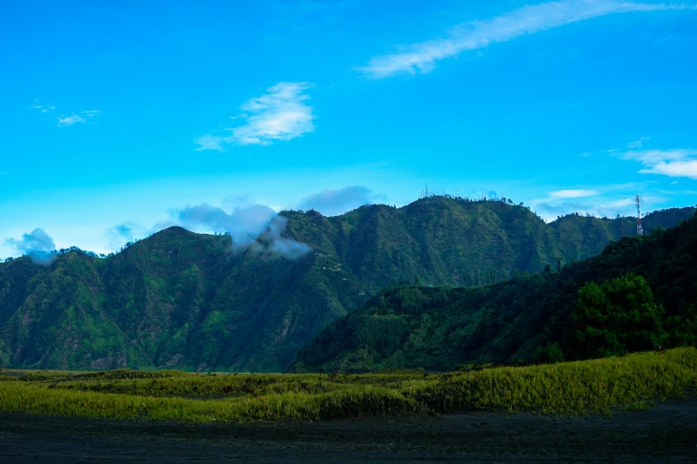 a lush green hillside under a partly cloudy sky