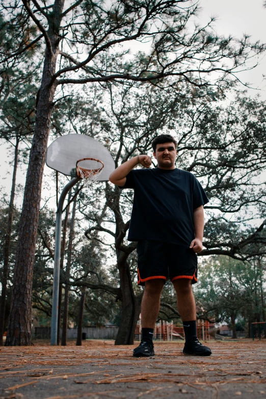 a man standing near a wooded area with his frisbee