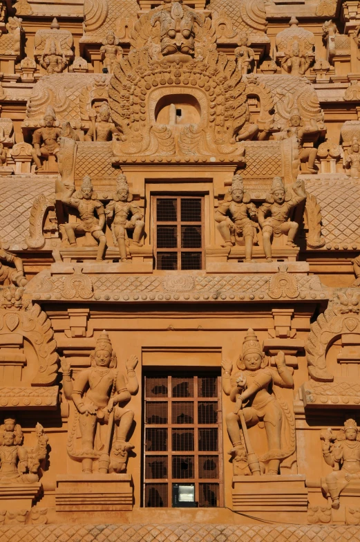 a decorative facade with statues and windows