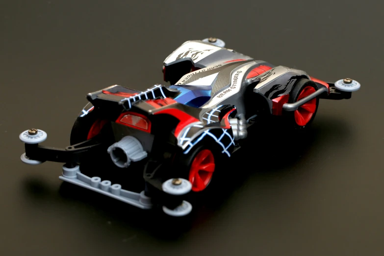 a car with red wheels on top of black table