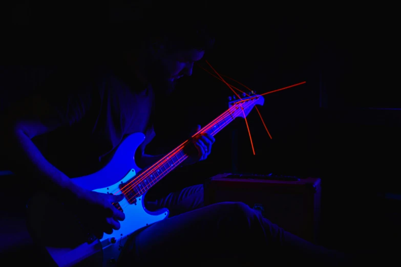 a person in a dimly lit room playing a guitar