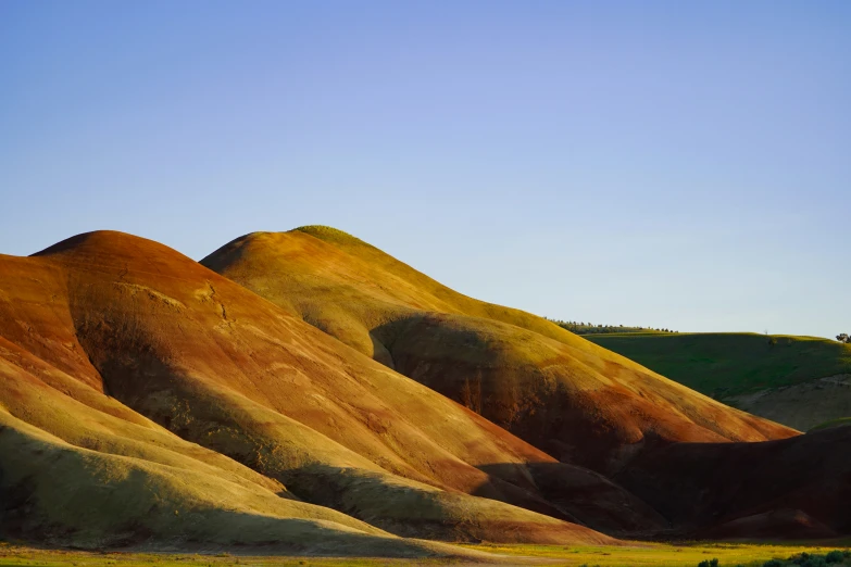 a hill filled with mountains under a blue sky