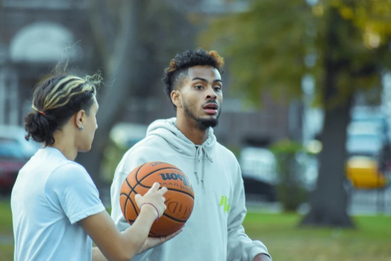 a man is holding a basketball while a woman looks on