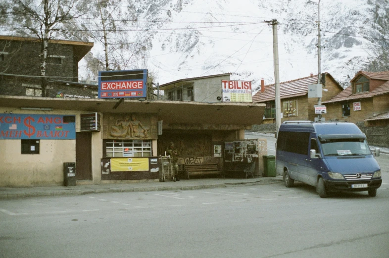 an suv driving through a city street in front of shops