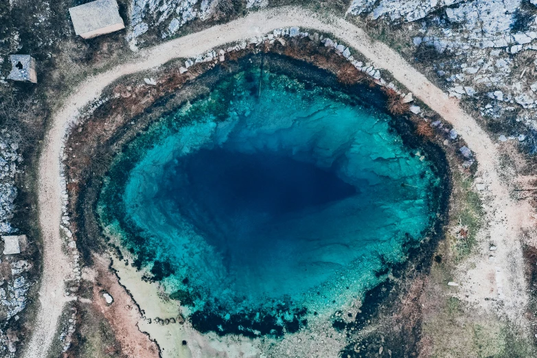 an aerial view of a blue hole in the ground