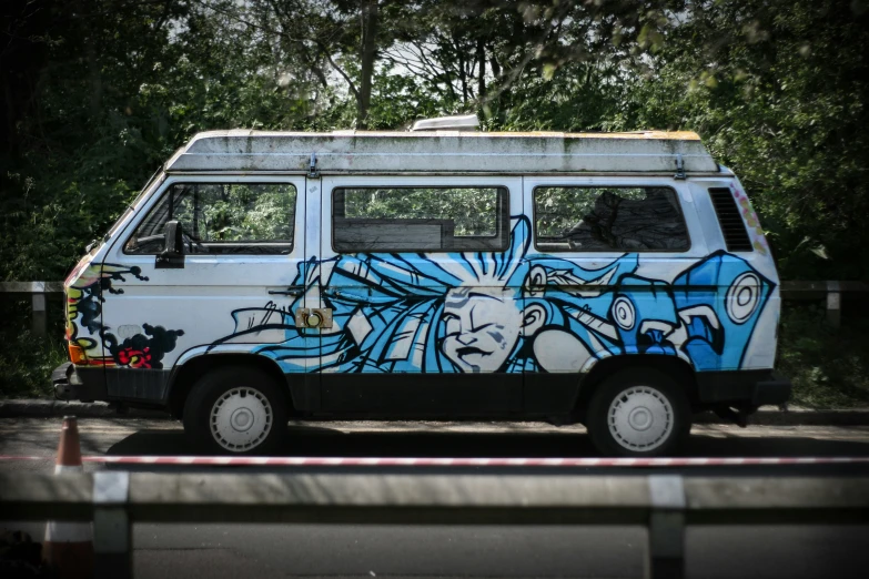 a van painted with graffiti driving down a road