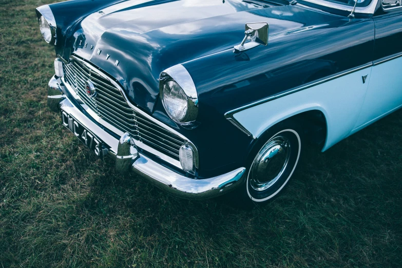 an old car parked on top of a grass covered field