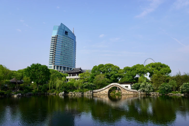 an arch bridge crossing over water in a park