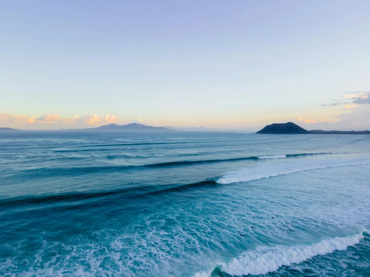 water waves crest over the sand as they approach shore