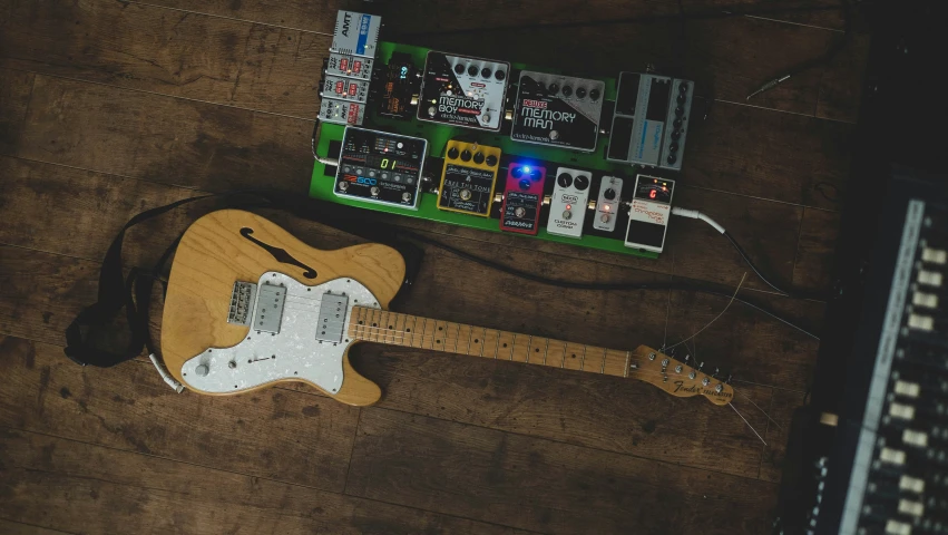 an electric guitar laying on a wooden floor