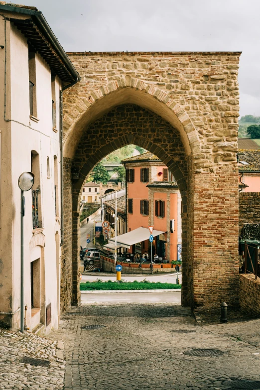 a brick arch on a cobble stone road