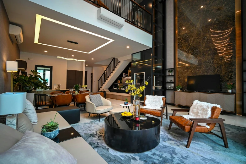 a living room with leather furniture and tall staircase