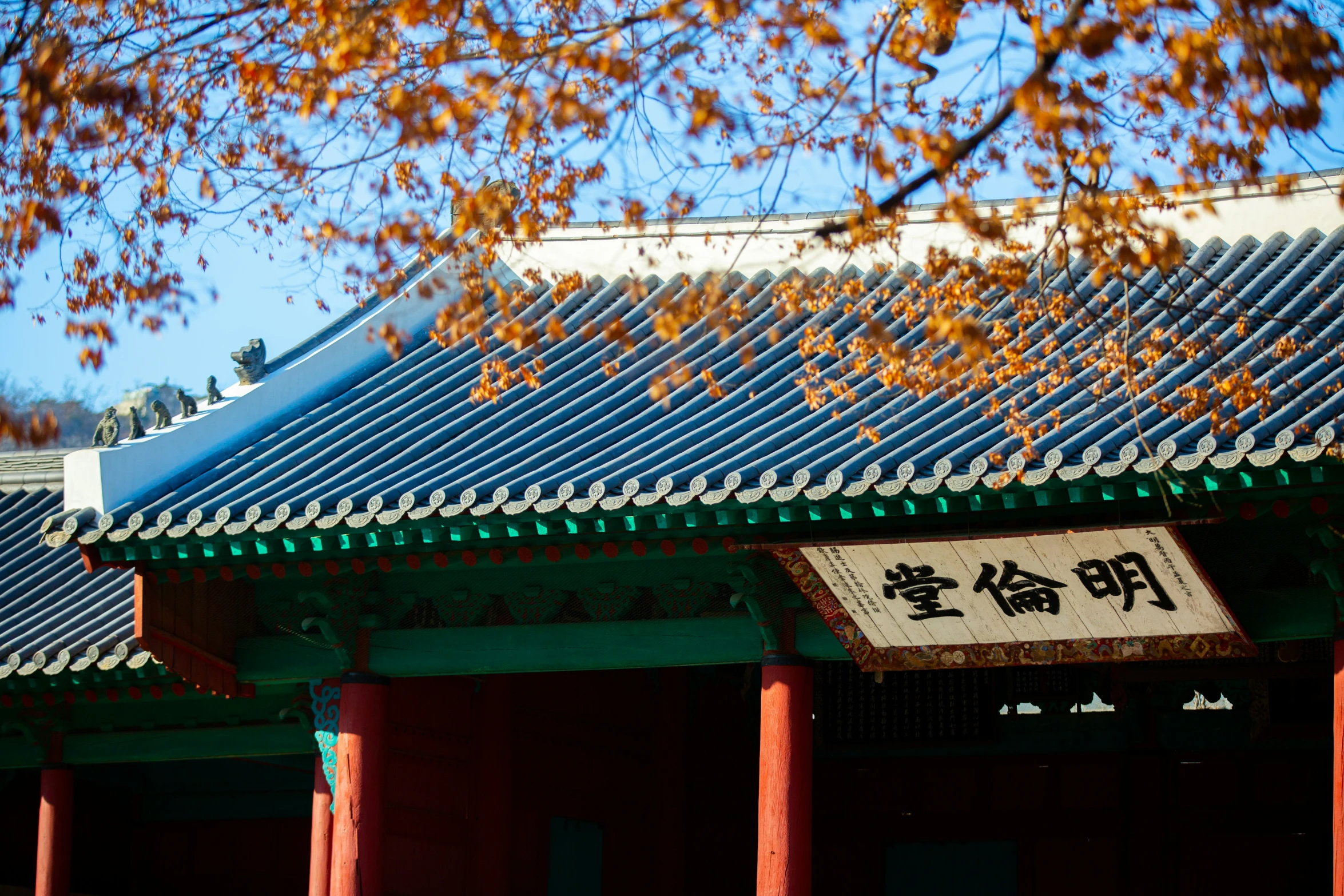 a asian building with large red pillars and a white sign