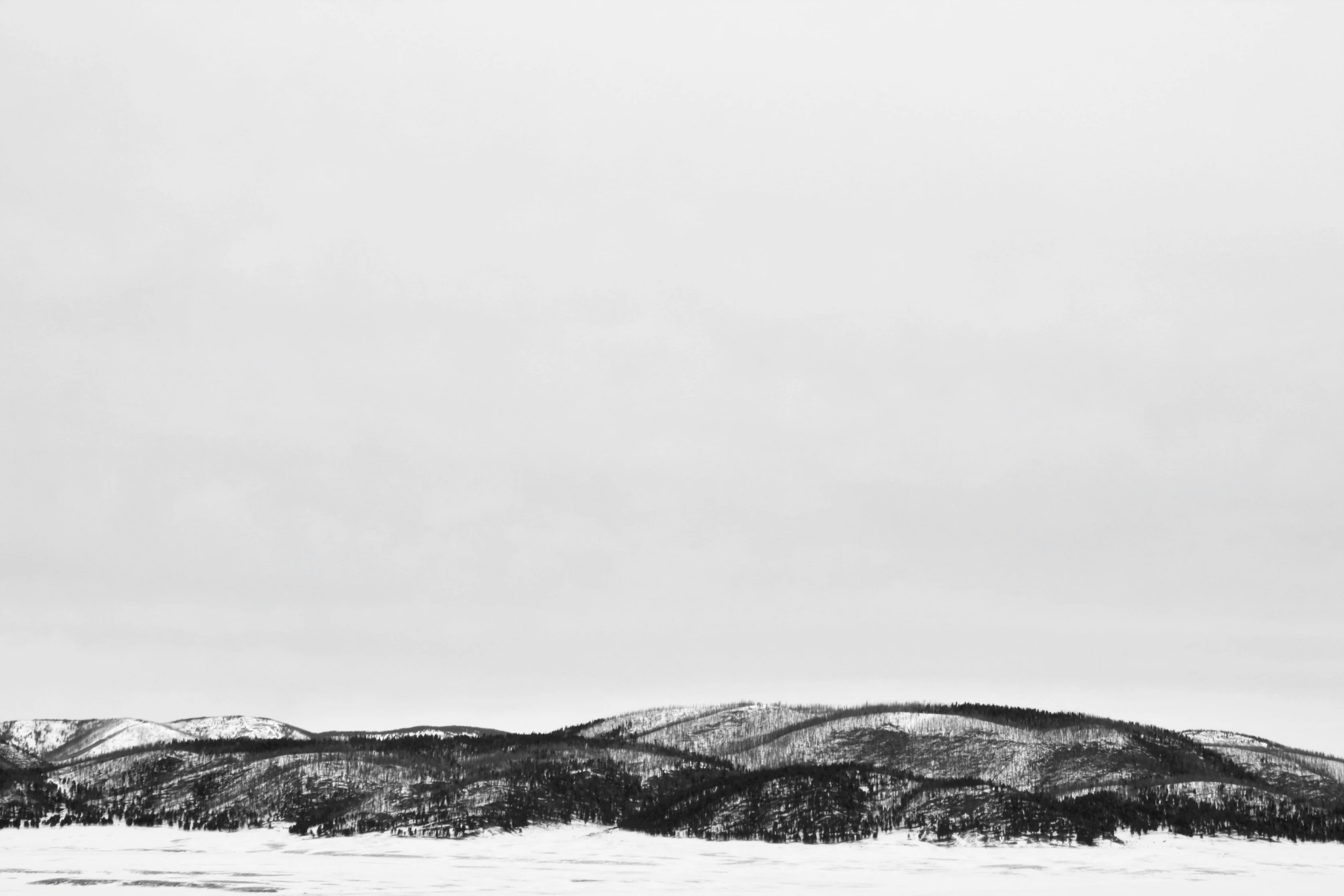 black and white pograph of a distant view of the snow - covered mountains