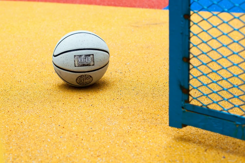 a basketball sitting on the ground next to a goal post