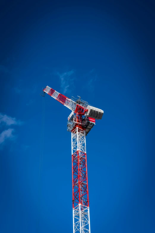 an elevated mobile crane sits against a clear blue sky