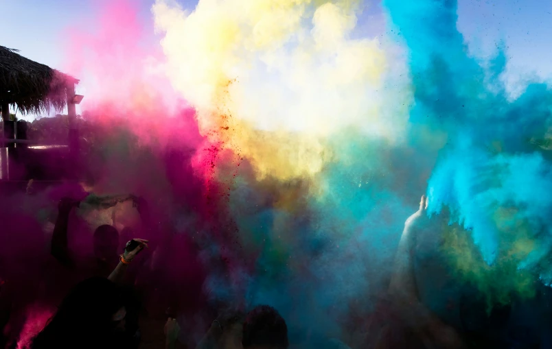 a person standing by colorful dust on a blue and green field