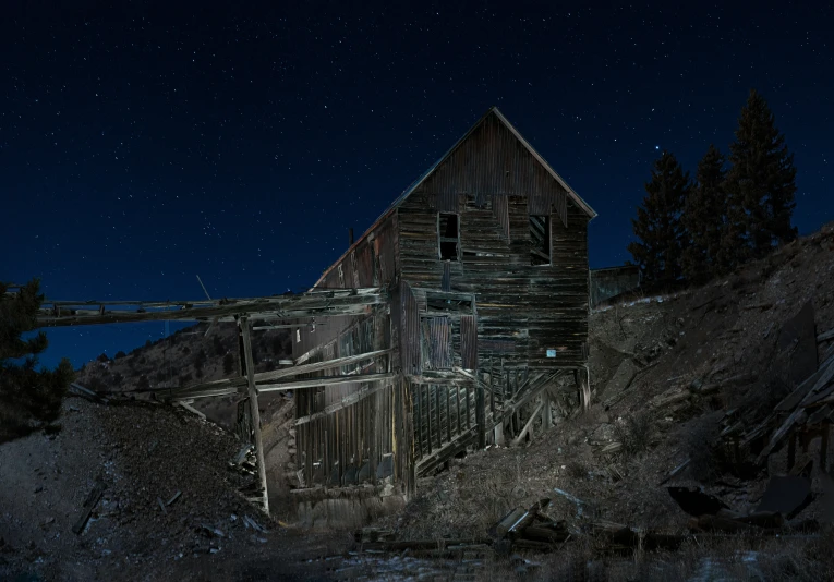an old barn is shown as it sits alone at night