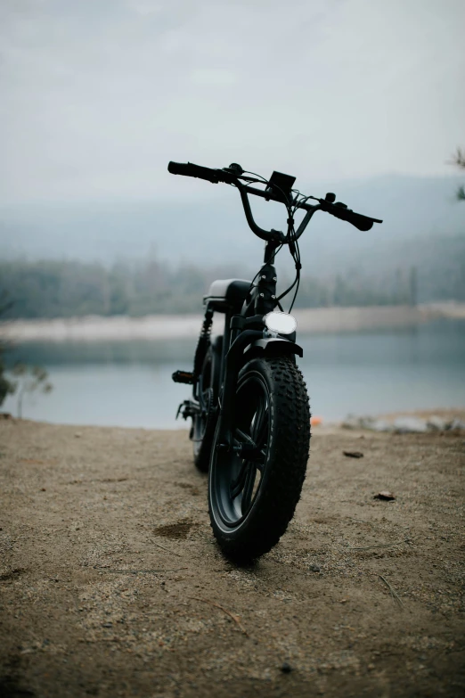 a bike parked on the sand by the water