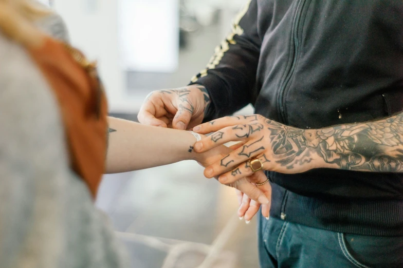 a close up of two people holding hands and giving each other