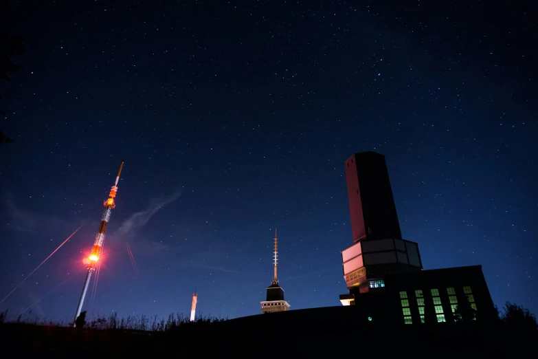 a nighttime view of the sky, with stars and a tower