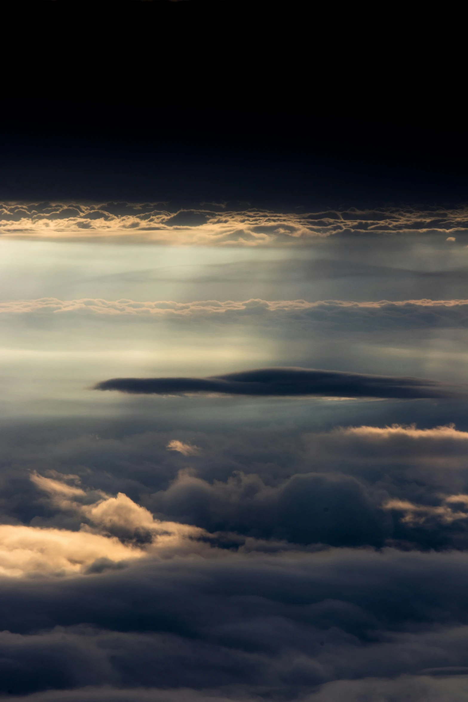 the sun is shining brightly through clouds from a plane