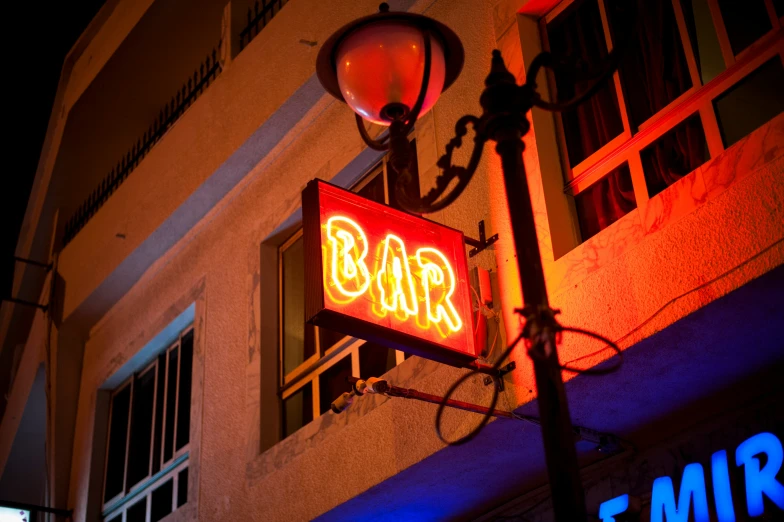 a neon bar sign is seen at night