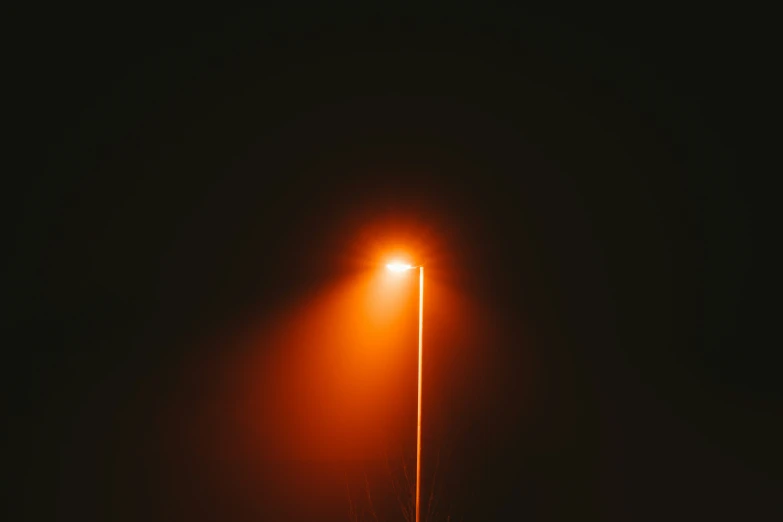 an empty street with a light up against the dark background