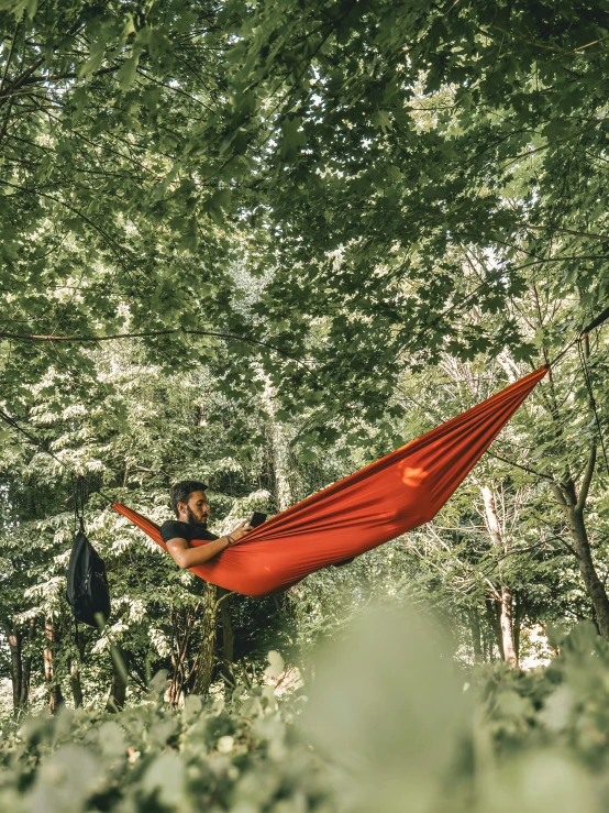 a man relaxing in a hammock in a forest