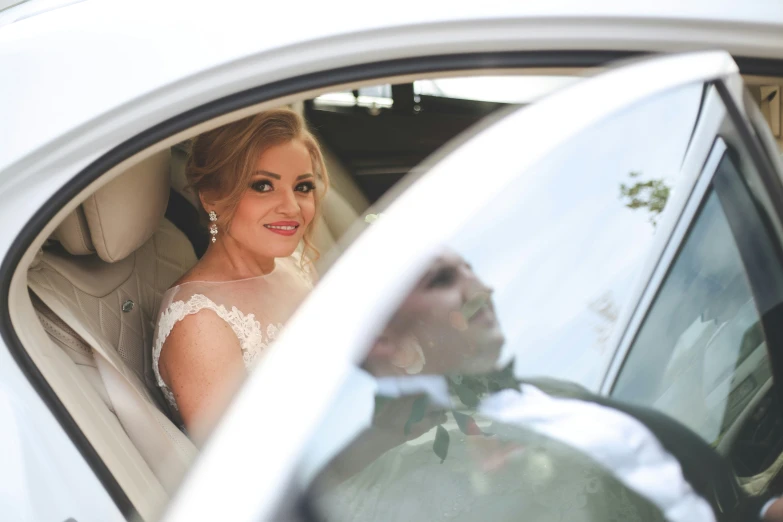 bride and groom sitting in the back seat of a car