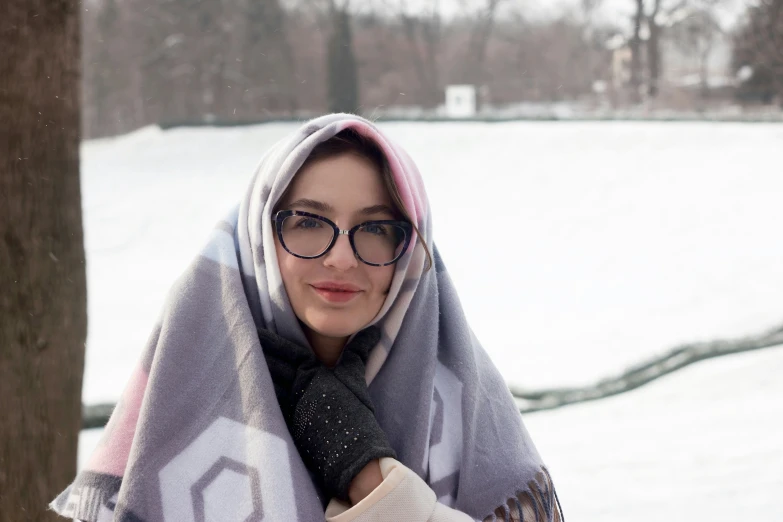 a beautiful woman wrapped in a blanket in the snow