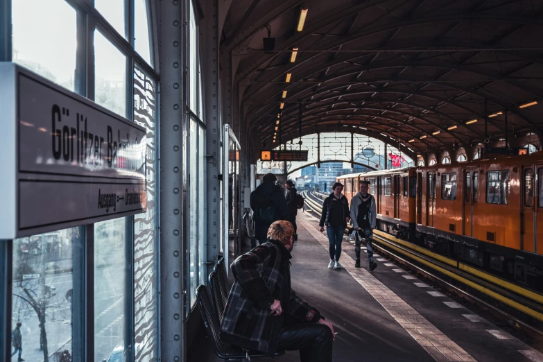 a number of people on their cell phones waiting for a train