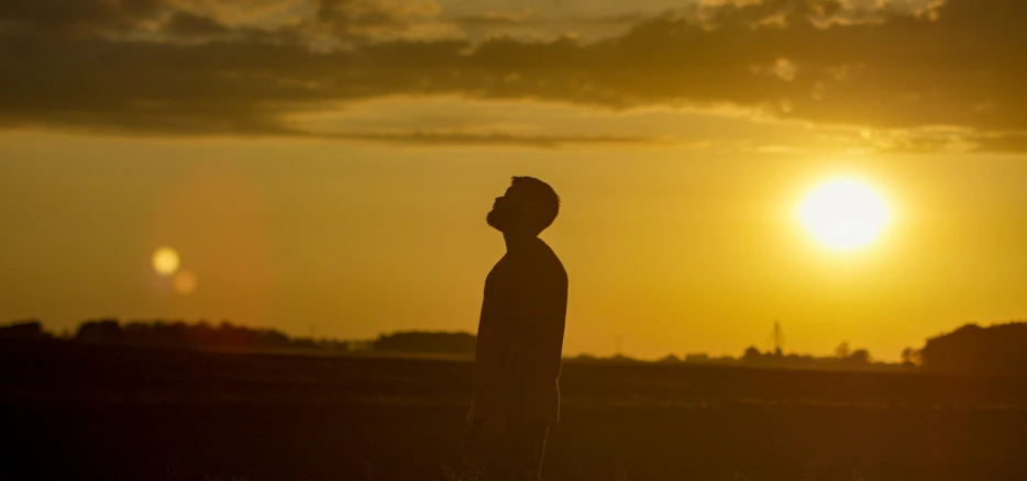 silhouette of a man on a sunset near water