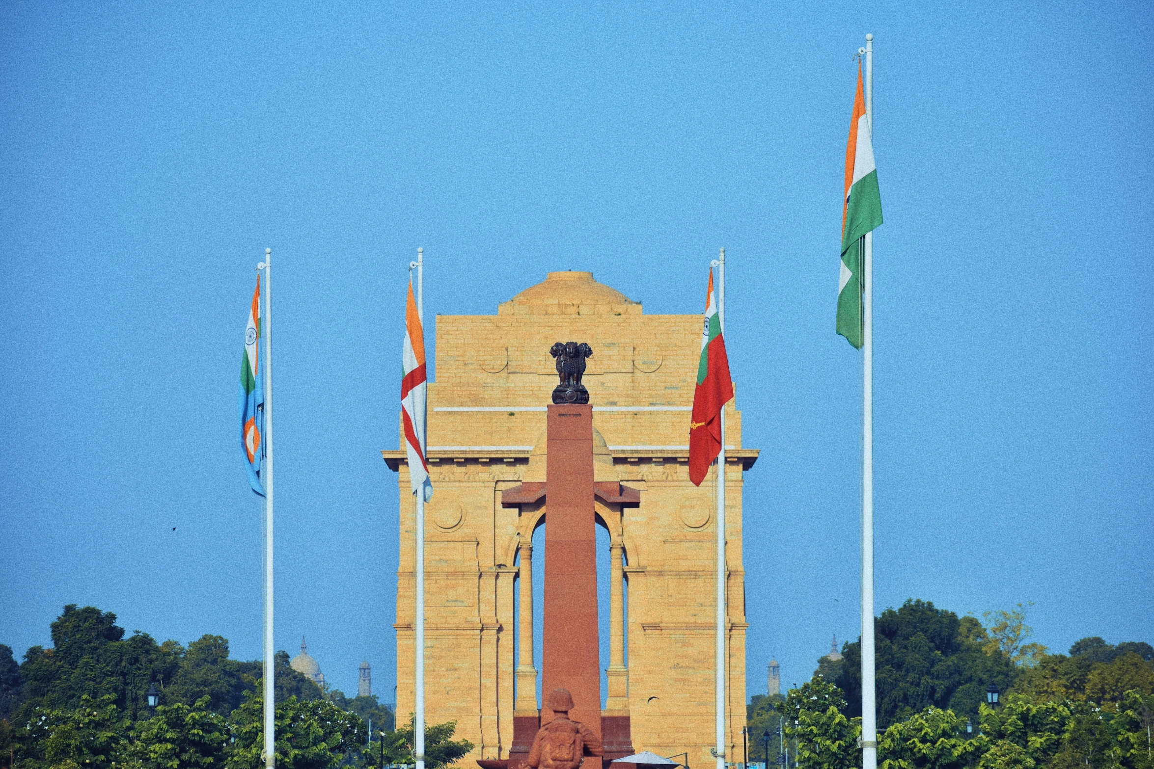 the american army memorial is framed by flags and a tall brick clock tower