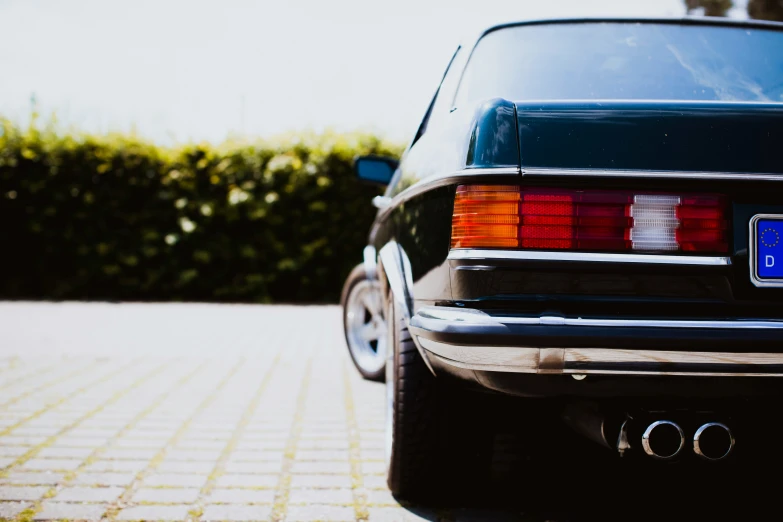 the back of an older black car with an emblem