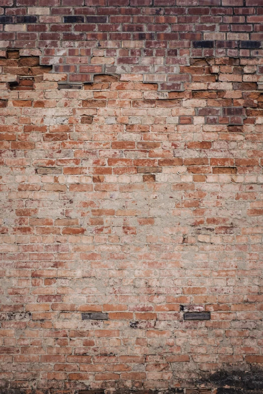 a red fire hydrant against a brown brick wall