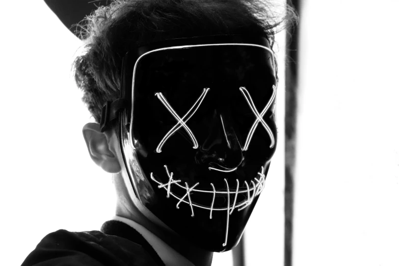 a person in a mask with the letter x painted on it