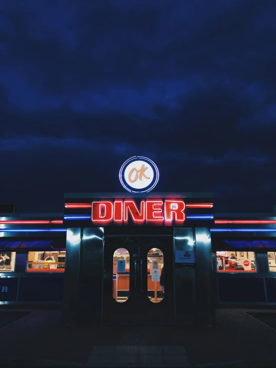 the front of a diner with a red neon sign