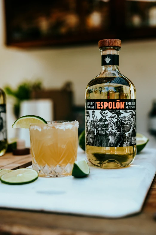 an orange and lime cocktail sits on a towel next to a glass