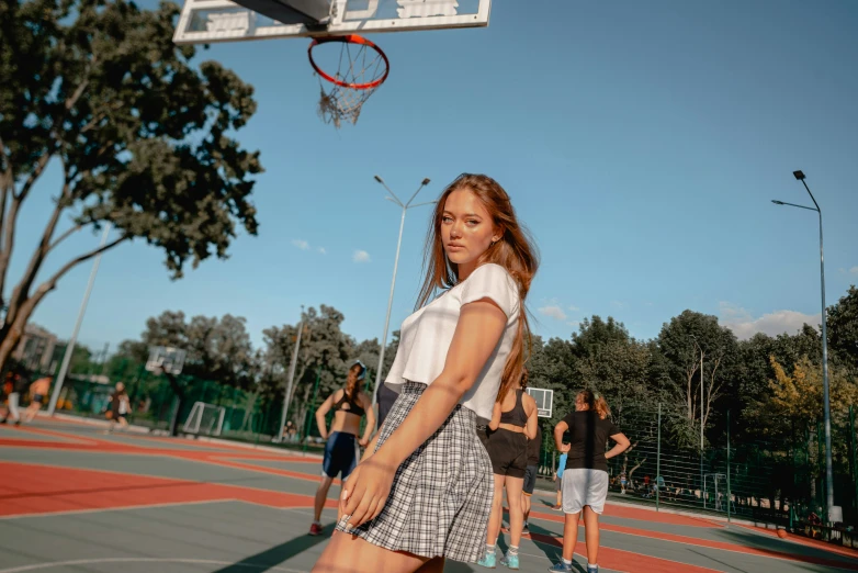 a woman standing on a basketball court holding a ball