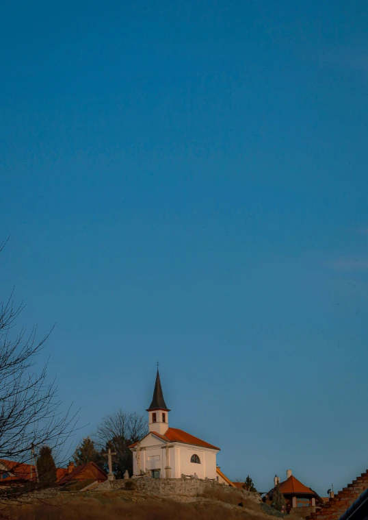 a church on a hill with buildings in the background
