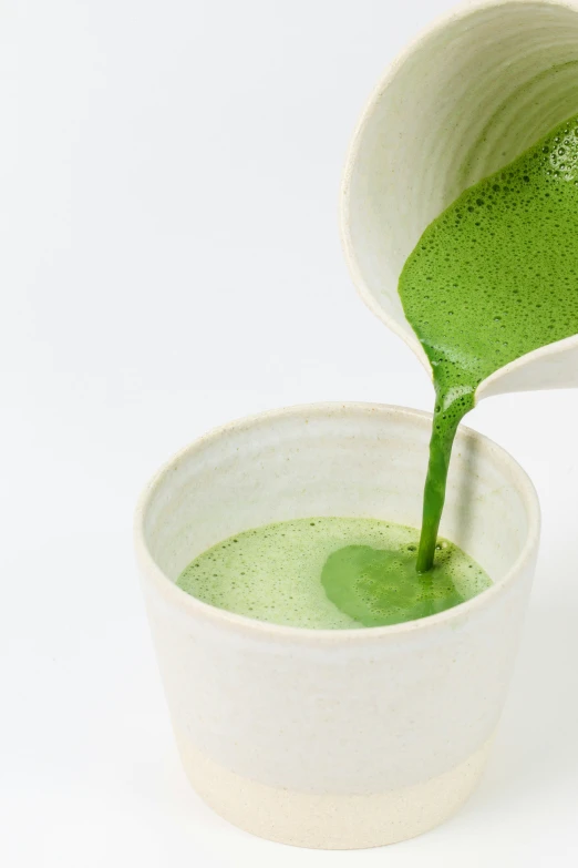 green liquid poured into small cups on a white background