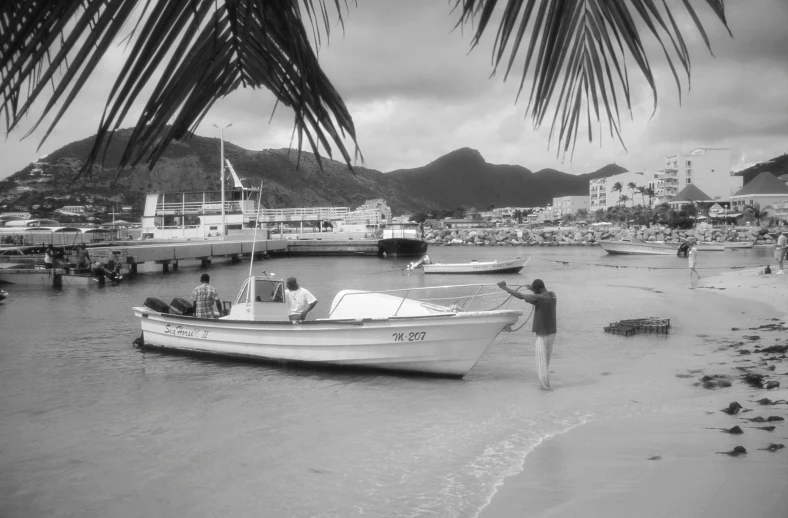 a group of people on a beach near a white boat