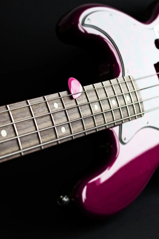 a red and white electric guitar with pink frette