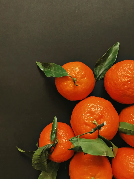 an orange sitting on top of green leaves