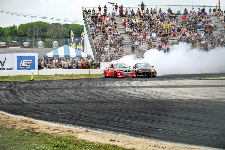 the car is turning into the smoke while on a dirt track