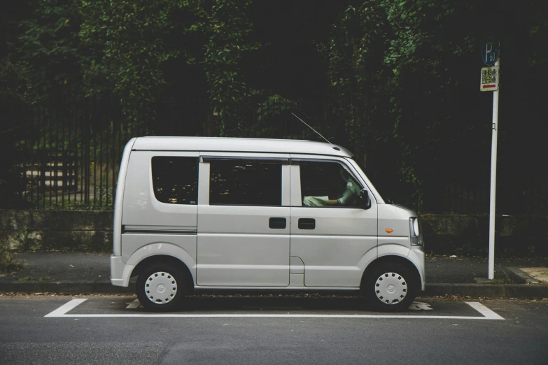 this is a van parked next to the tree line