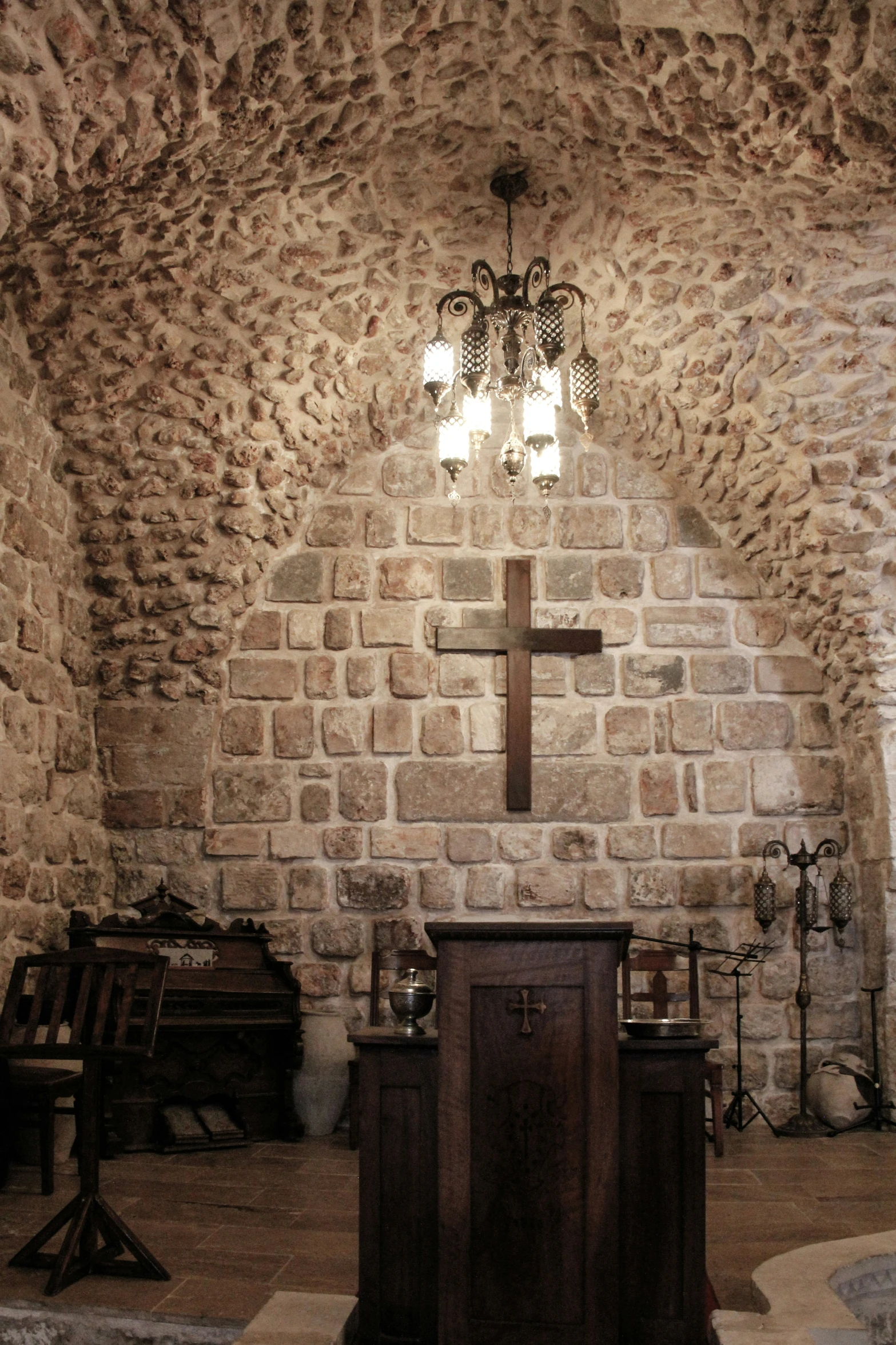 inside a church, pews and a crucifix with lights on