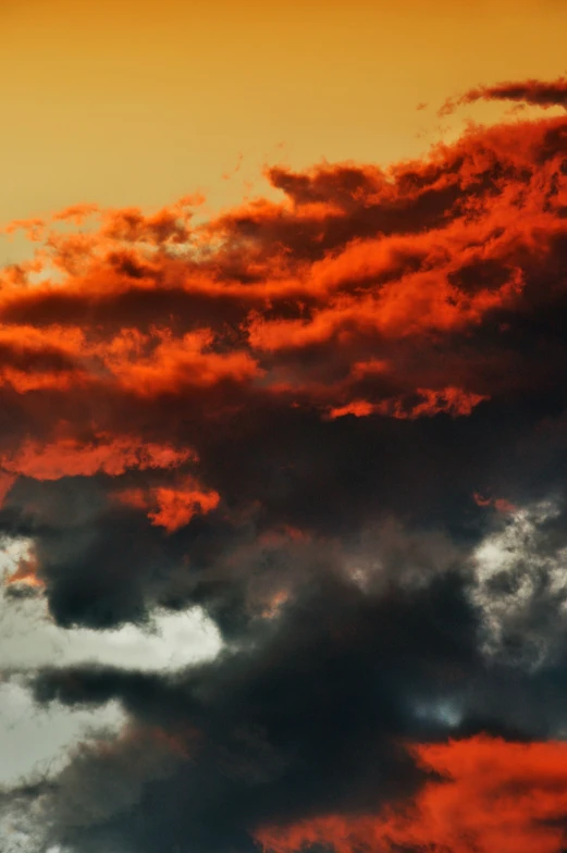 a red and yellow sky with some dark clouds