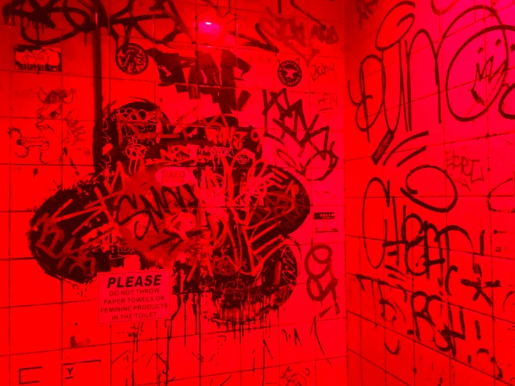 graffiti and street signs decorate a public toilet